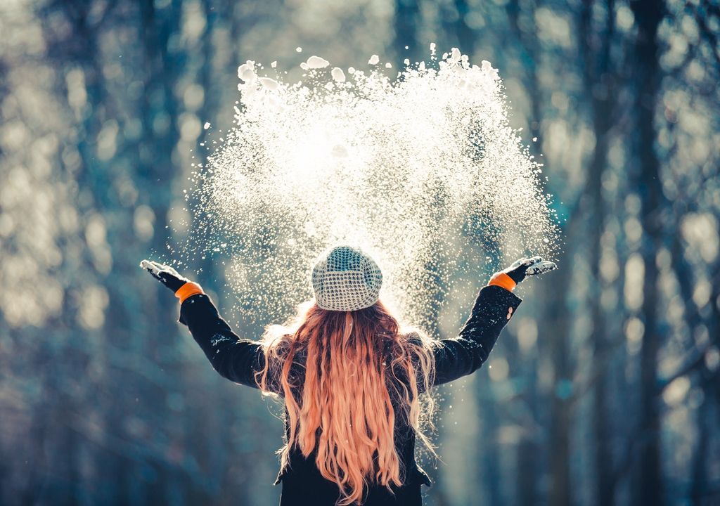 Mujer tirando nieve hacia arriba