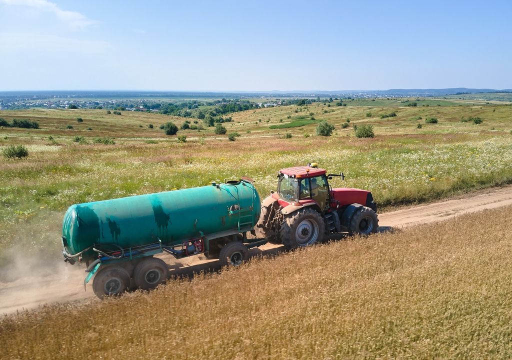 tanque de agua siendo transportado por un tractor tanque de agua siendo transportado por un tractor