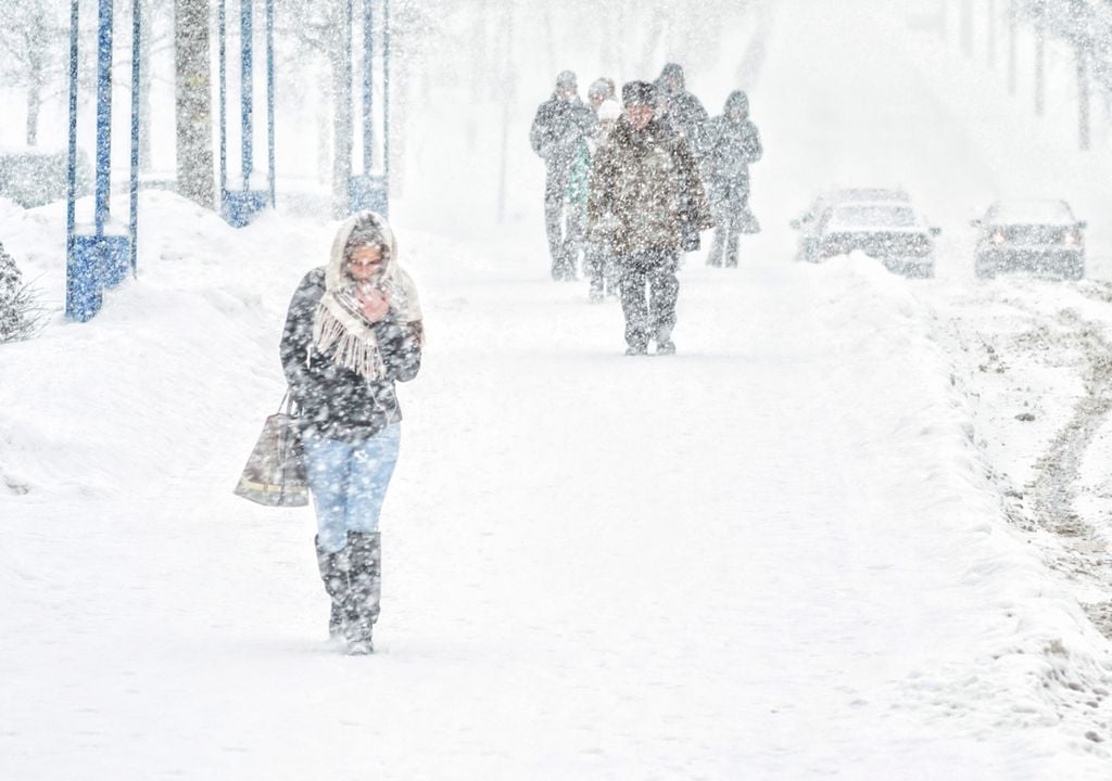 Nevando y gente andando por la calle