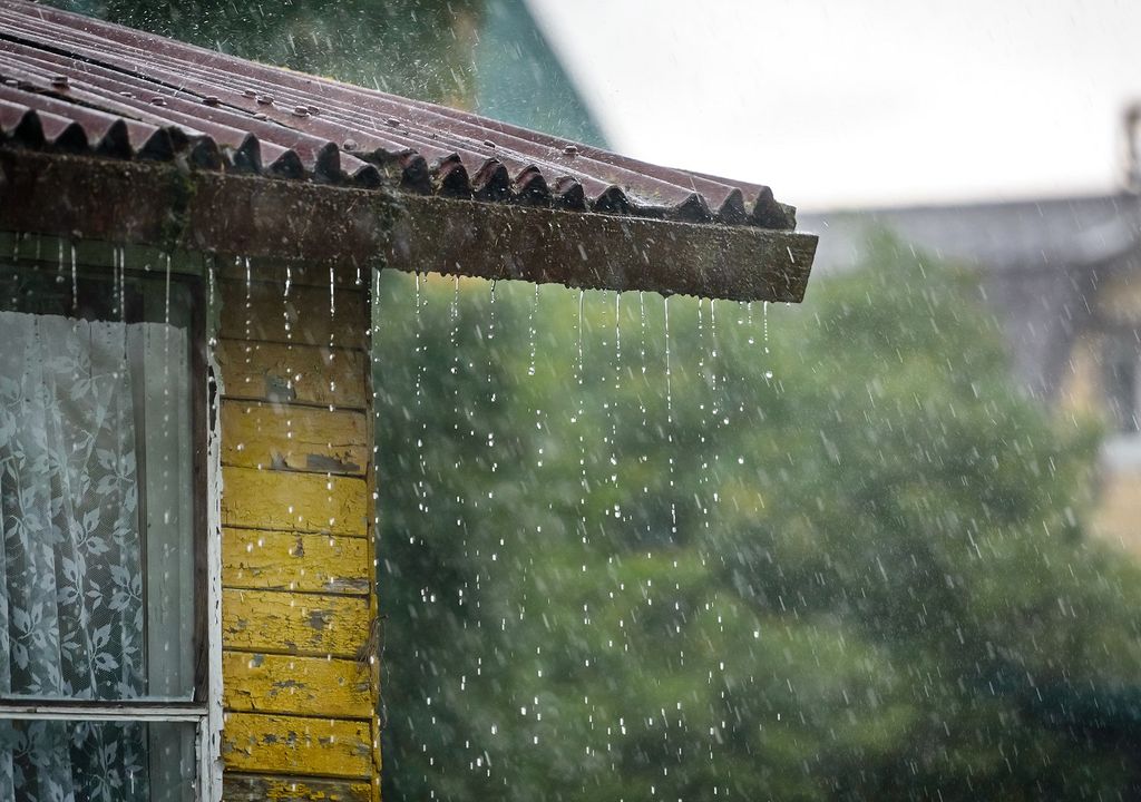 Lluvia cayendo desde el tejado de una casa