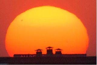 Sol y mancha solar entre humos