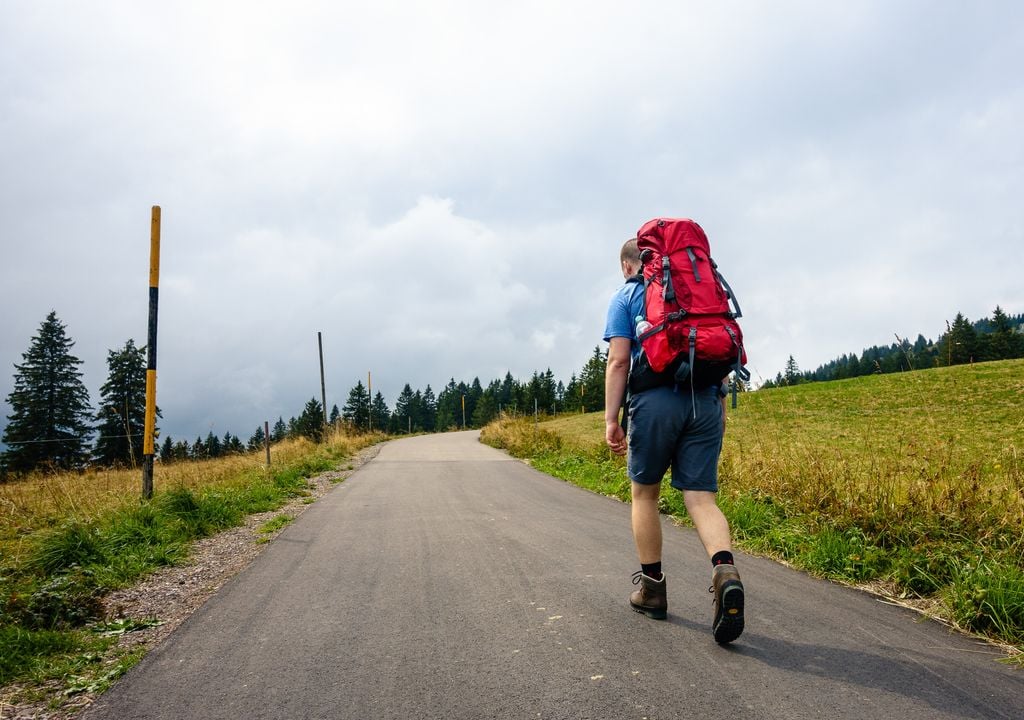 Ein Wanderer im Schwarzwald erklimmt den Pfad bei wechselhaftem Wetter