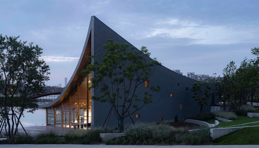 Grandes paños de vidrio conectan el interior de la librería con el espejo de agua durante todo el recorrido del sol. Crédito: MUDA Architects y Arch Daily