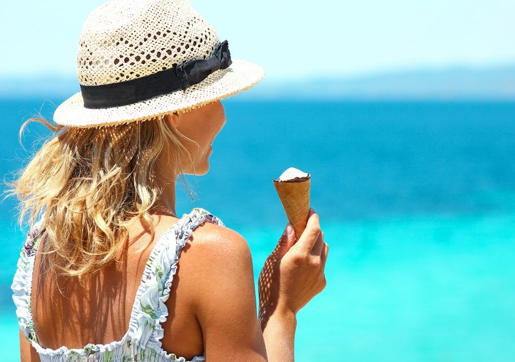 mujer tomando helado; playa