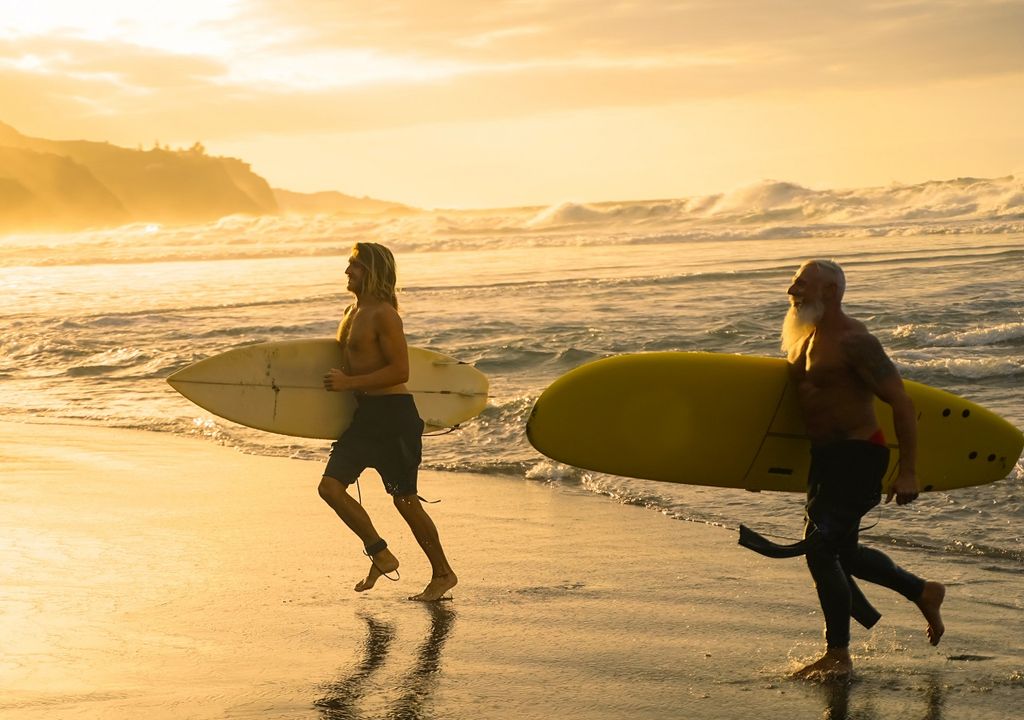 padre e hijo haciendo surf al atardecer