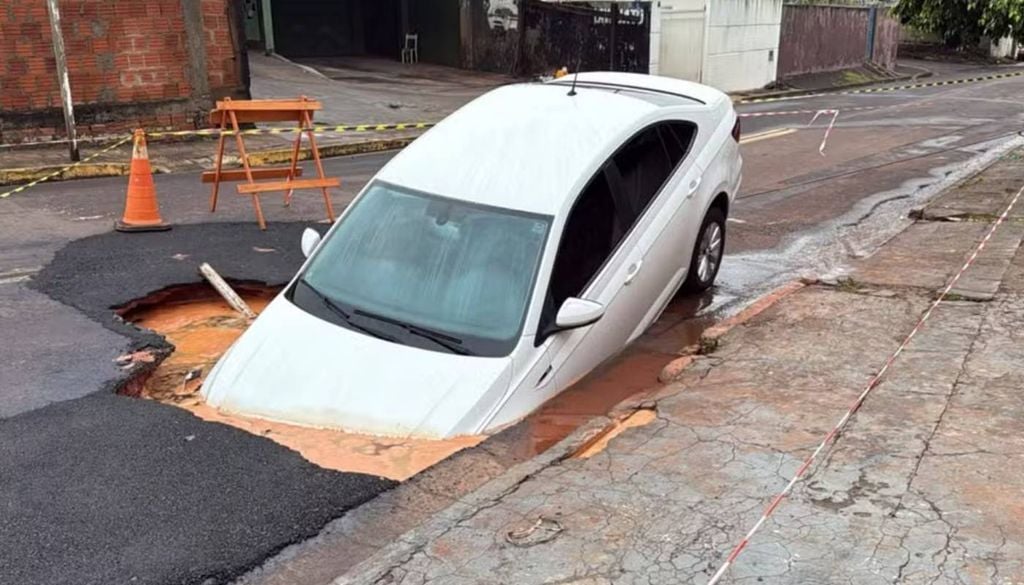 Asfalto cedeu após a chuva e o carro ficou preso em cratera no MS. Foto: Giovanna Dauzacker, TV Morena Asfalto cedeu após a chuva e o carro ficou preso em cratera no MS. Foto: Giovanna Dauzacker, TV Morena
