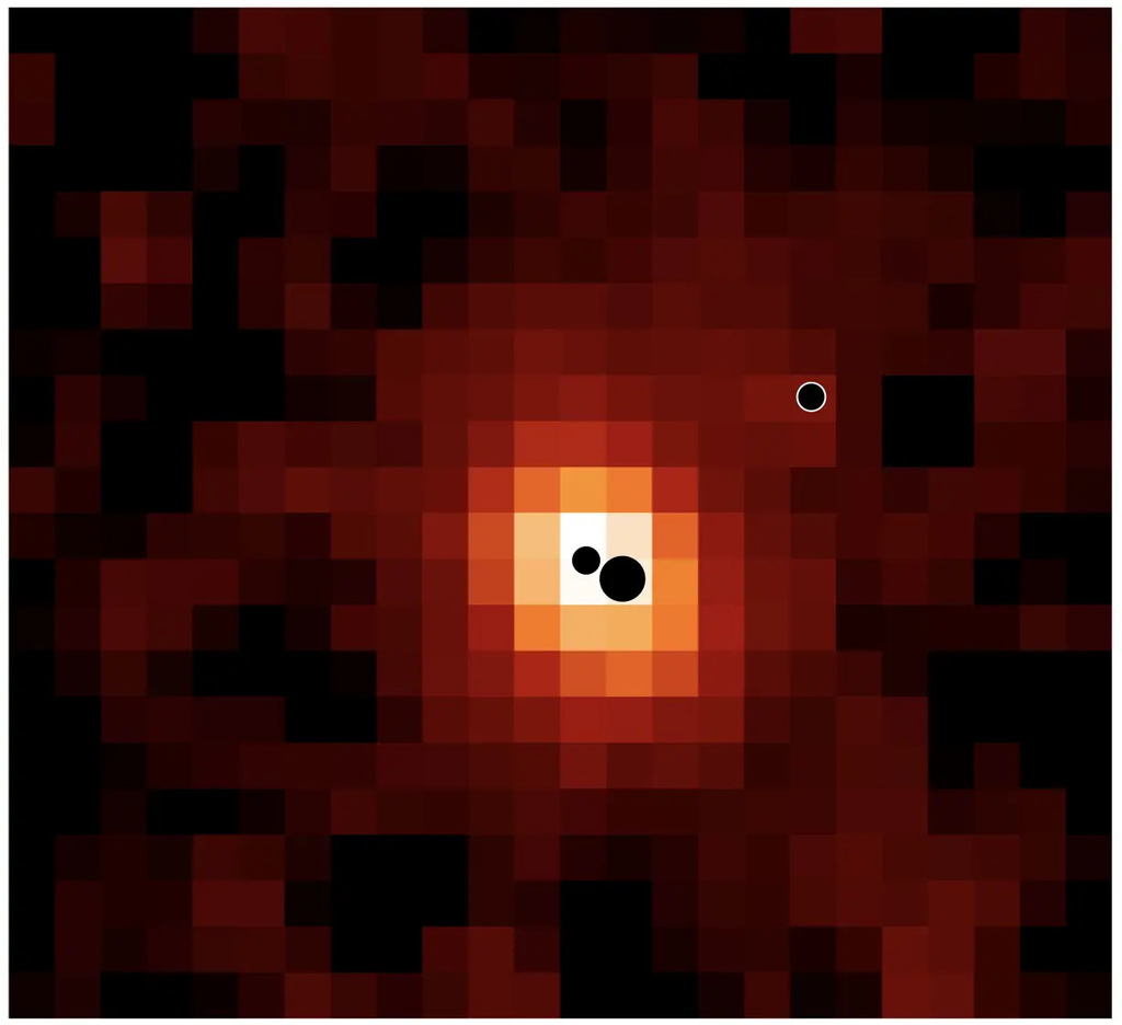 Una imagen pixelada de una zona central de color claro rodeada de tonos rojos oscuros, con tres círculos negros de diferentes tamaños cerca del centro y en el extremo derecho. Mapa de la galaxia distante J0148-4214 en hidrógeno ionizado (Hα). © Hannah Übler