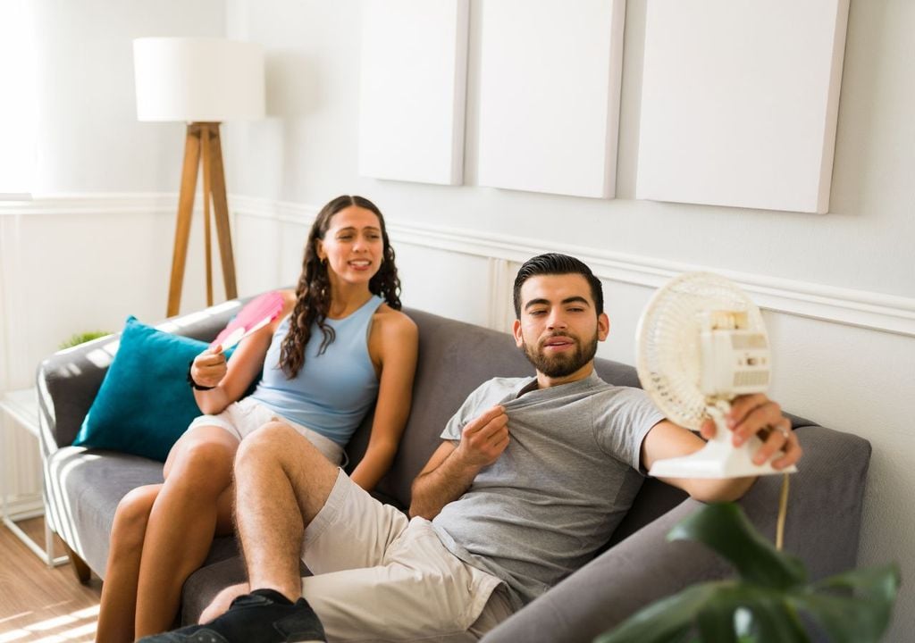 Hombre y mujer con ventilador Hombre y mujer con ventilador
