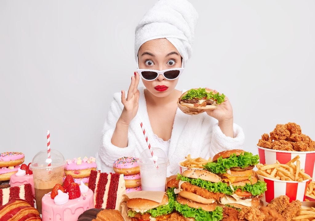 Mujer vestida de blanco frente a mesa con alimentos ultra procesados