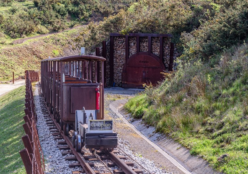La entrada de El Soplao, con su antiguo tren minero, anuncia el viaje al interior de la tierra en medio de los verdes valles cántabros que rodean la cueva.