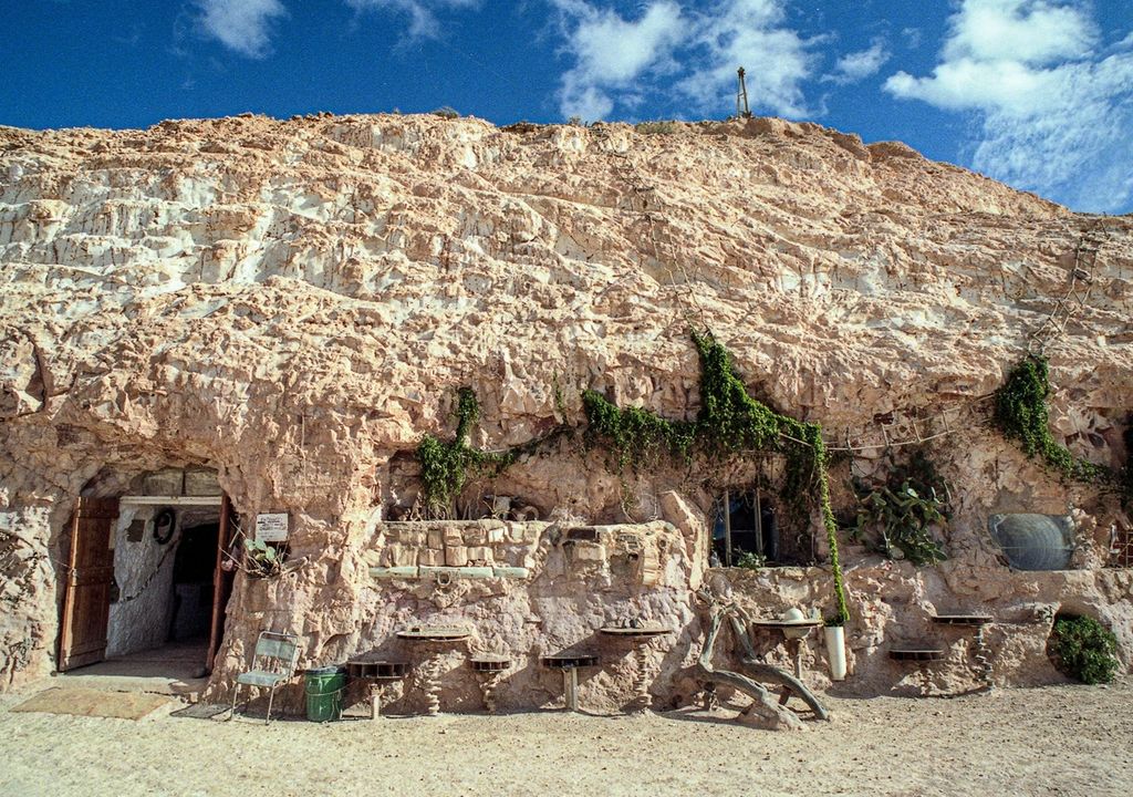 Casa bajo una montaña de piedra