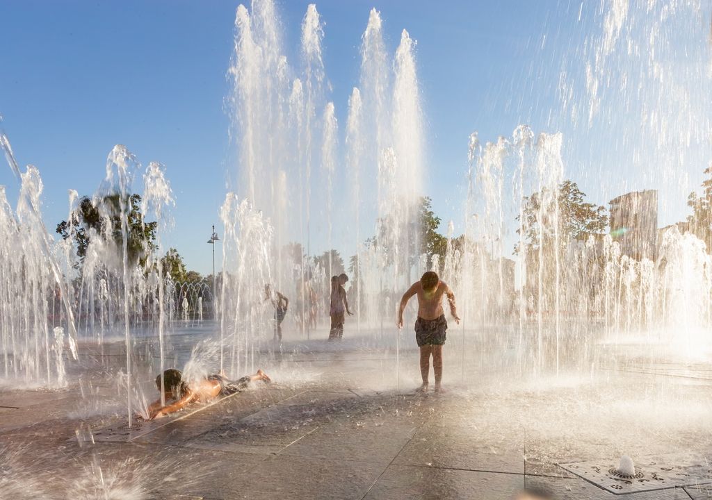 Niños jugando con agua en una plaza