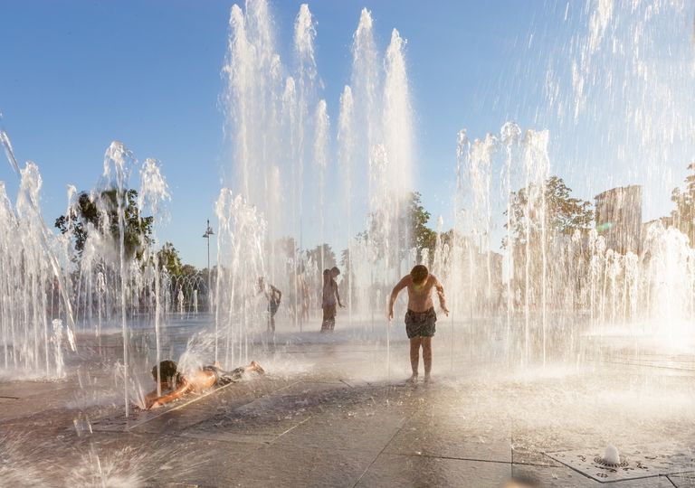 Niños jugando con agua en una plaza Niños jugando con agua en una plaza