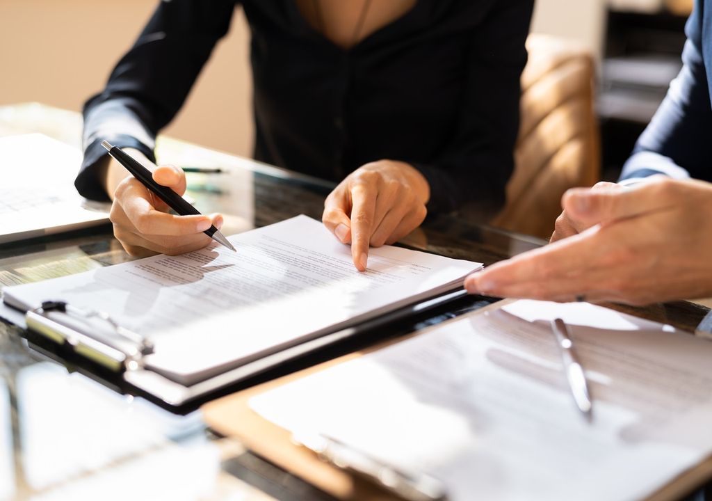 Personas con documentos sobre escritorio Personas con documentos sobre escritorio