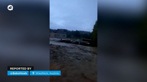Fuertes inundaciones cubren Wiesfleck, Austria, arrastrando vehículos a su paso.